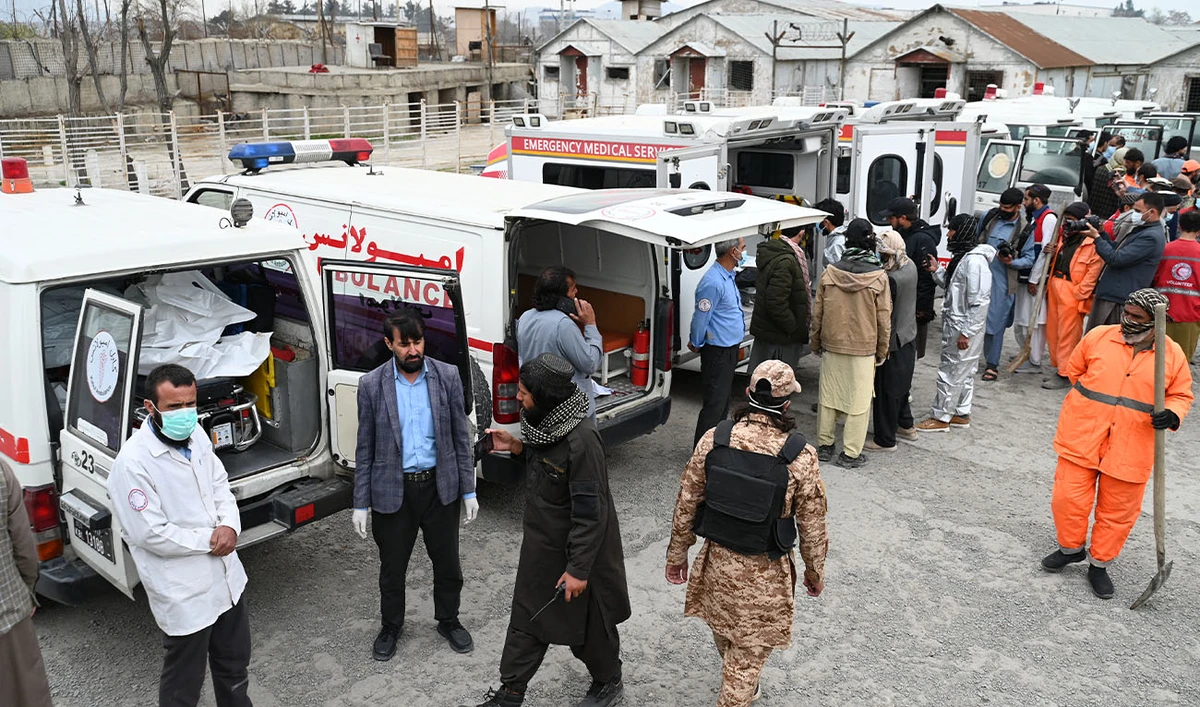 Ambulances carrying the victims' bodies arrive at the site as Afghans wait for their deceased relatives after Pakistani airstrikes hit the Omid Addiction Treatment Hospital in Kabul, on March 17, 2026. (AFP/File)