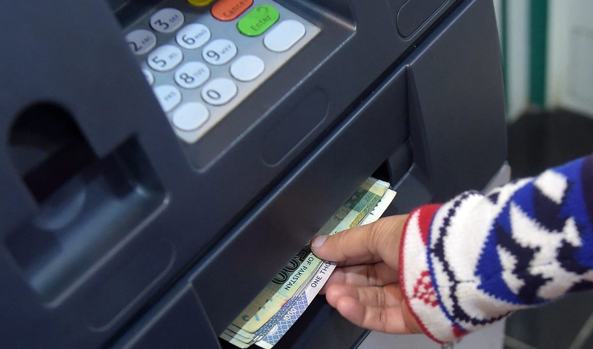 This photograph taken on March 6, 2015 shows a Pakistani resident withdrawing currency from an ATM in Islamabad. (AFP/File)