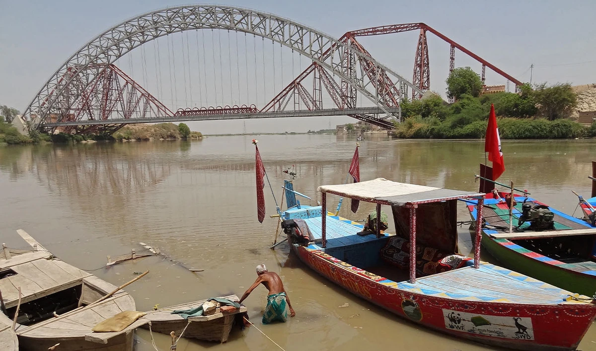 A man wades next to his boat along the Indus River near the Lansdowne Bridge in Sukkur, in the southern Sindh province on April 28, 2025. (AFP/File)