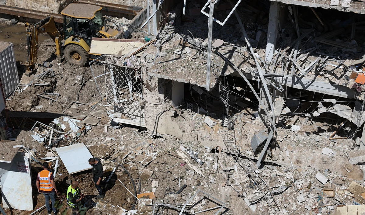 Israeli emergency service personnel gather at the site of an Iranian missile strike in Tel Aviv on March 24, 2026. (AFP)