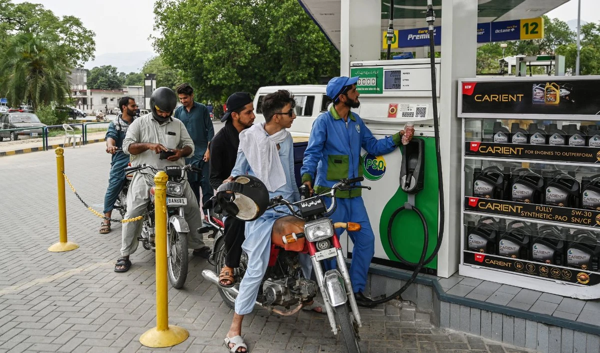 An employee fills the tank of a motorbike at a fuel station in Islamabad on June 16, 2025, after a hike in prices of petroleum products by the government. (AFP/ file)