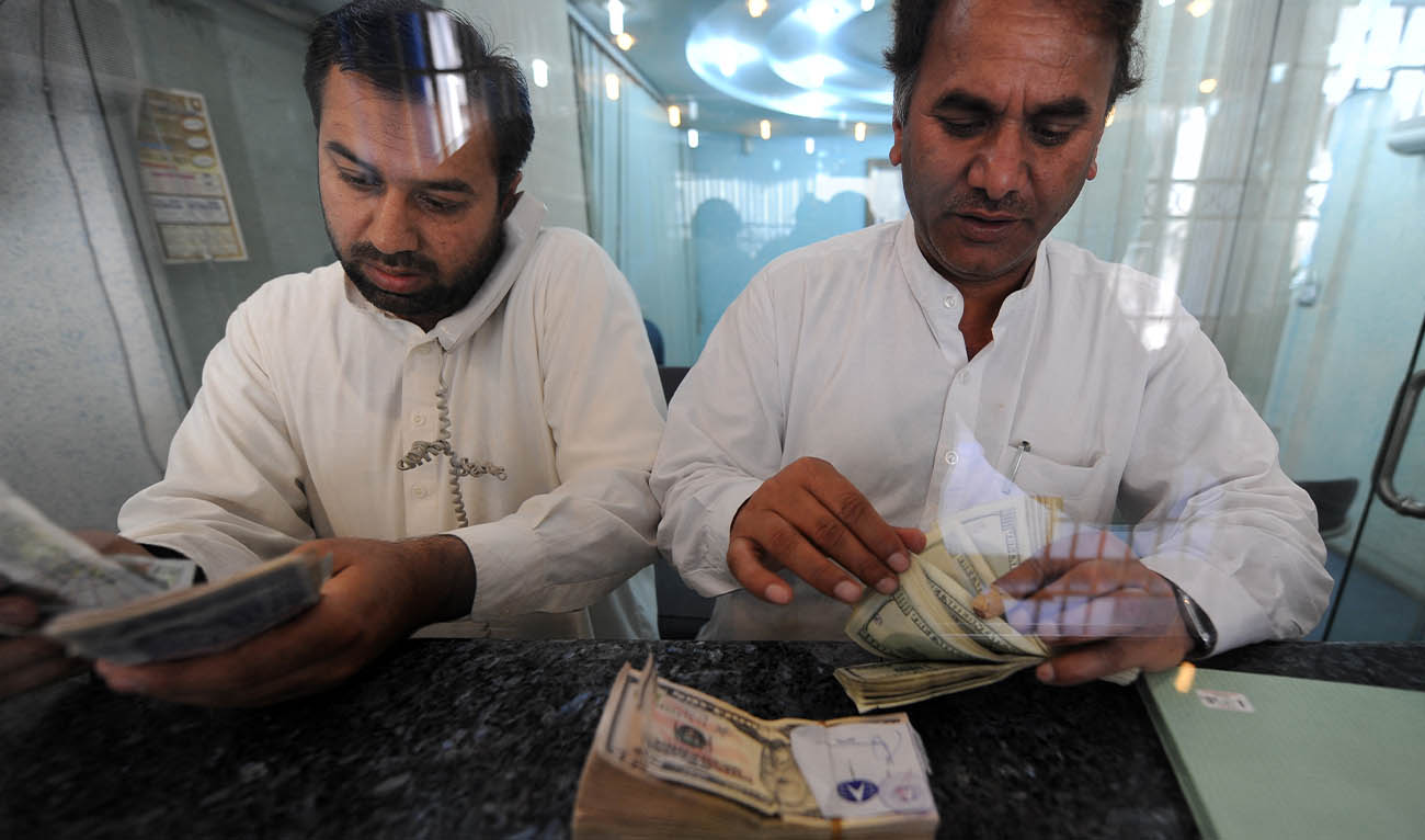 Pakistani money dealers count US dollars and other currency notes at a money market in Islamabad on April 20, 2009. (AFP/ file)