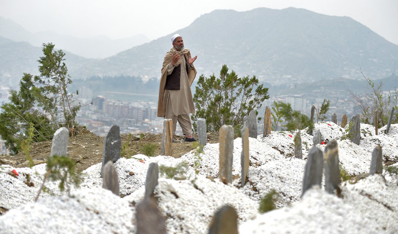 This photograph taken on April 1, 2026 shows an Afghan man praying near the graves of victims killed during Pakistani airstrikes on a drug rehabilitation centre, at the Badam Bagh Hilltop in Kabul. (AFP/File)