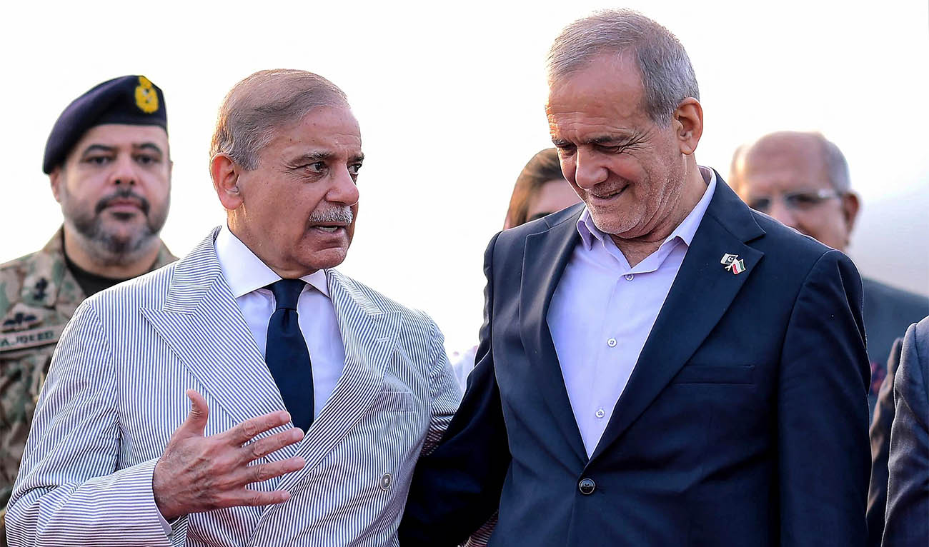 This handout photograph taken on August 2, 2025 and released by Pakistan's Prime Minister Office shows Pakistan's Prime Minister Shehbaz Sharif (L) speaking with Iran's President Masoud Pezeshkian upon the latter's arrival at the airport in Islamabad. (AFP/ file)