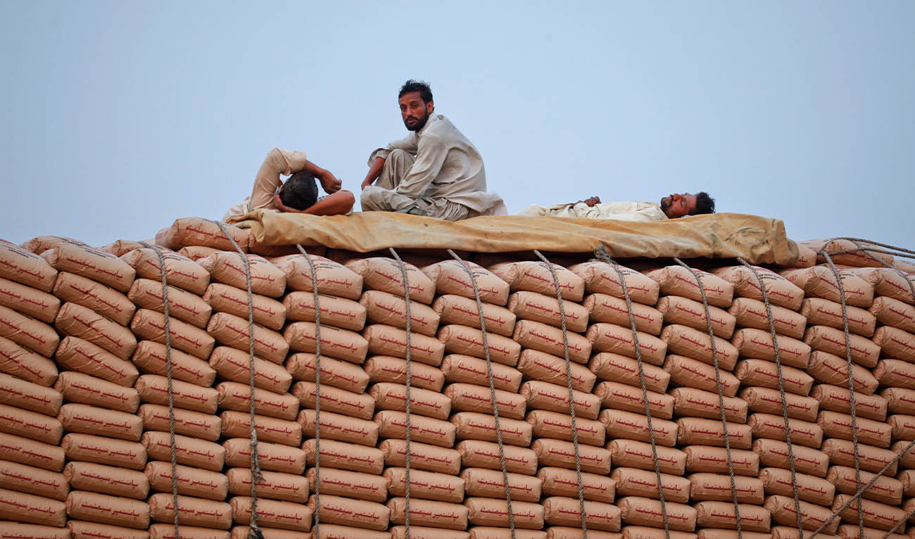 Men travel on a supply truck transporting sacks of cement through Lahore June 24, 2011. (REUTERS)