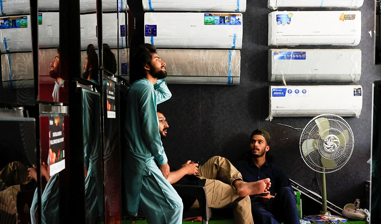 Workers take a break during a power outage at an electronic appliances shop at a market in Islamabad, Pakistan, April 16, 2026. (Reuters/File)