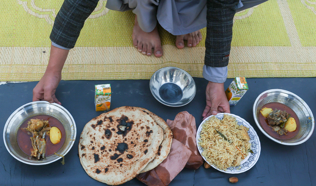 A person arranges plates of food to break the fast, during the Muslim holy month of Ramadan, at a mosque in Peshawar, Pakistan, February 19, 2026. (Reuters/File)