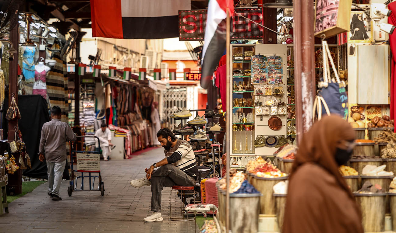 A shop keeper looks at his phone in the Dubai old Souk on April 13, 2026. (AFP/ file)