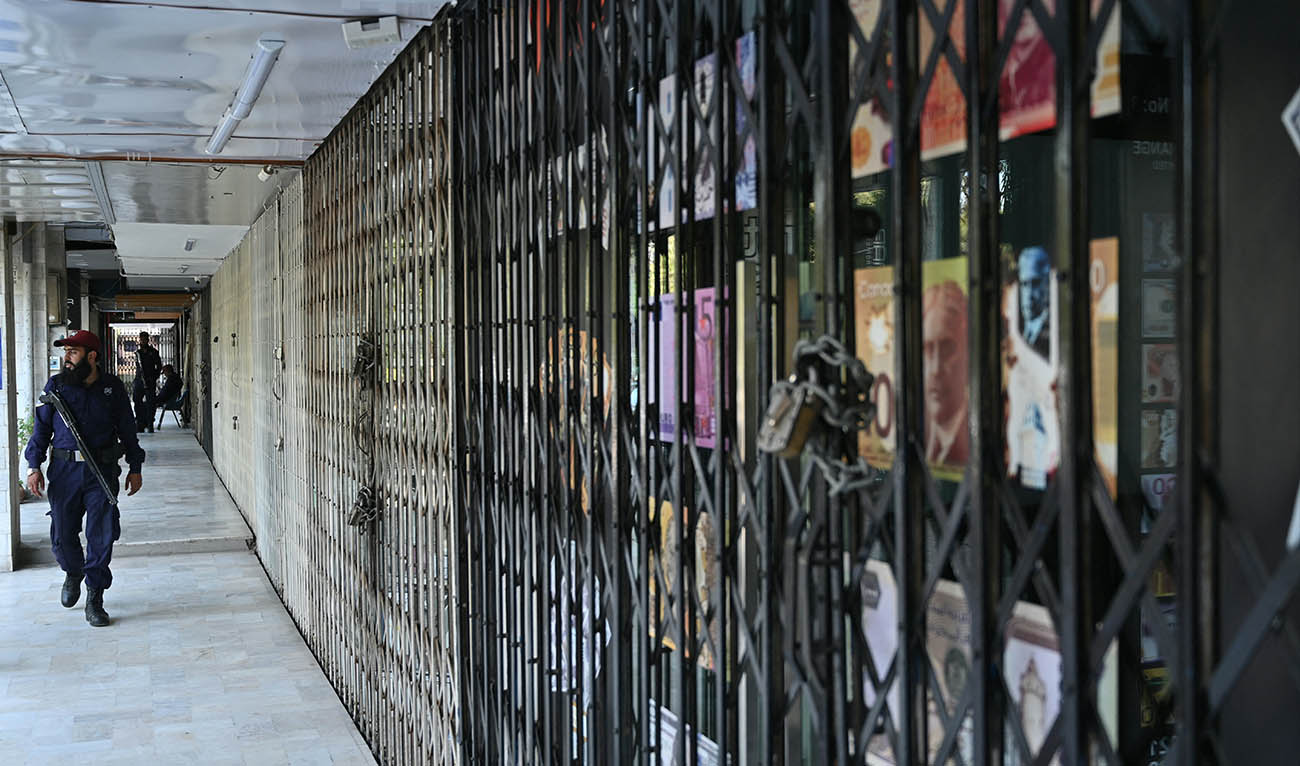 A security guard walks past closed shops near the Red Zone area in Islamabad on April 21, 2026, amid heightened security measures ahead of anticipated US-Iran peace talks. (AFP)