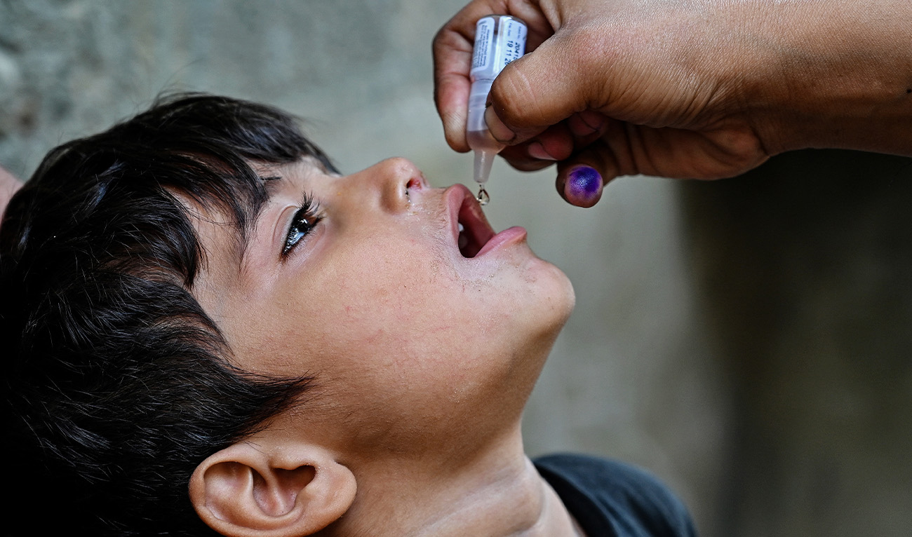 A health worker administers polio drops to a child for vaccination on the first day of a nationwide week-long poliovirus eradication campaign in Karachi on October 13, 2025. (AFP/File)
