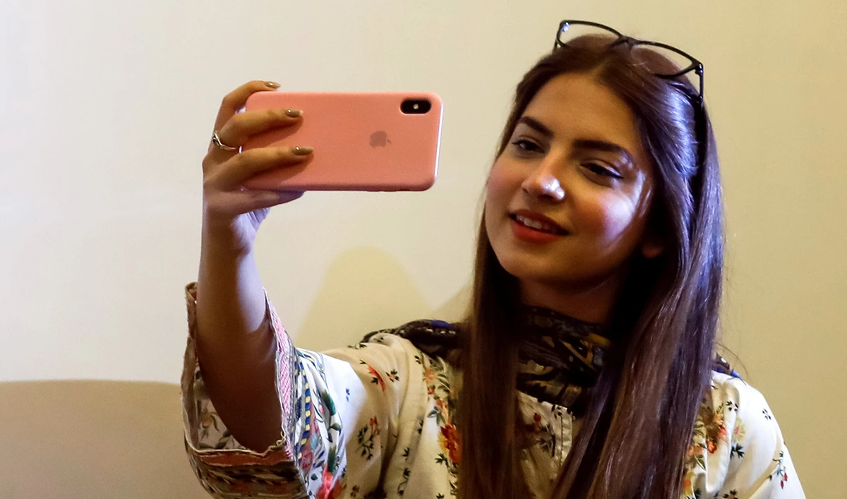 Dananeer Mobeen, a social media influencer, looks at her mobile phone during an interview with Reuters, in Karachi, Pakistan, on February 27, 2021. (Reuters/File)