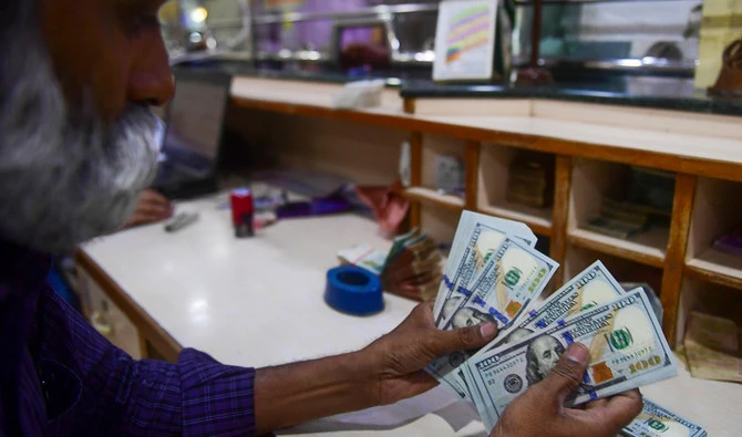A foreign currency dealer counts US dollars at a shop in Karachi on May 19, 2022. (AFP/File)
