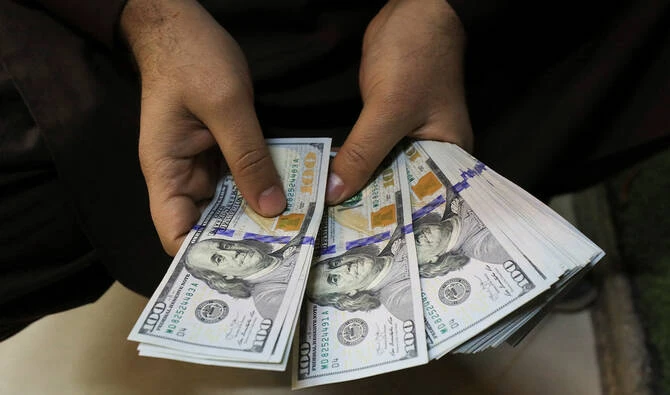 A trader counts US dollar banknotes at a currency exchange booth in Peshawar, Pakistan January 25, 2023. (Reuters/File)