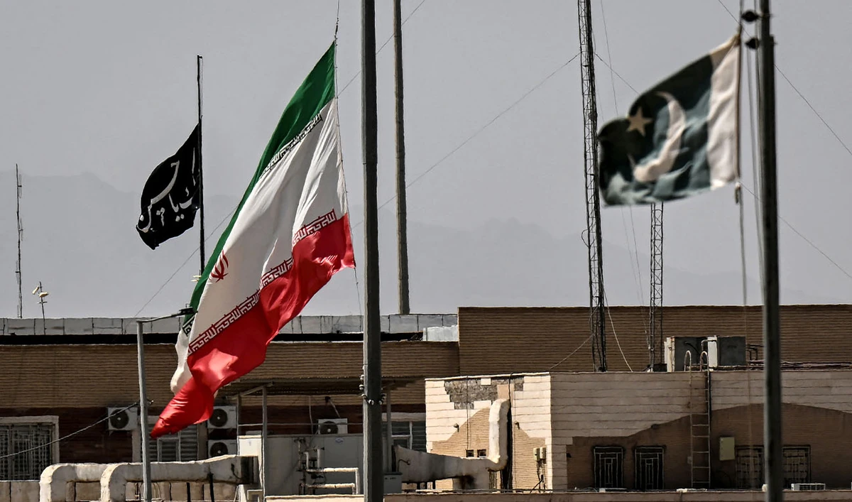 An Iranian flag (C) flies at half-mast at the Pakistan-Iran border crossing at Taftan, Balochistan province on March 4, 2026. (AFP/File)