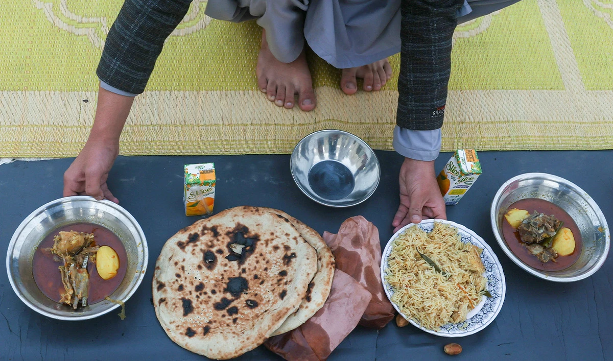 A person arranges plates of food to break the fast, during the Muslim holy month of Ramadan, at a mosque in Peshawar, Pakistan, February 19, 2026. (Reuters/File)