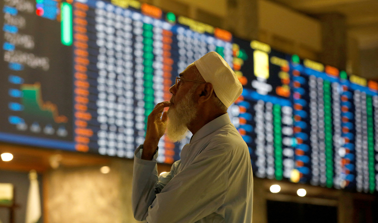 A stock broker reacts while monitoring the market on the electronic board displaying share prices during trading session at the Pakistan Stock Exchange, in Karachi, Pakistan July 3, 2023. (Reuters/File)
