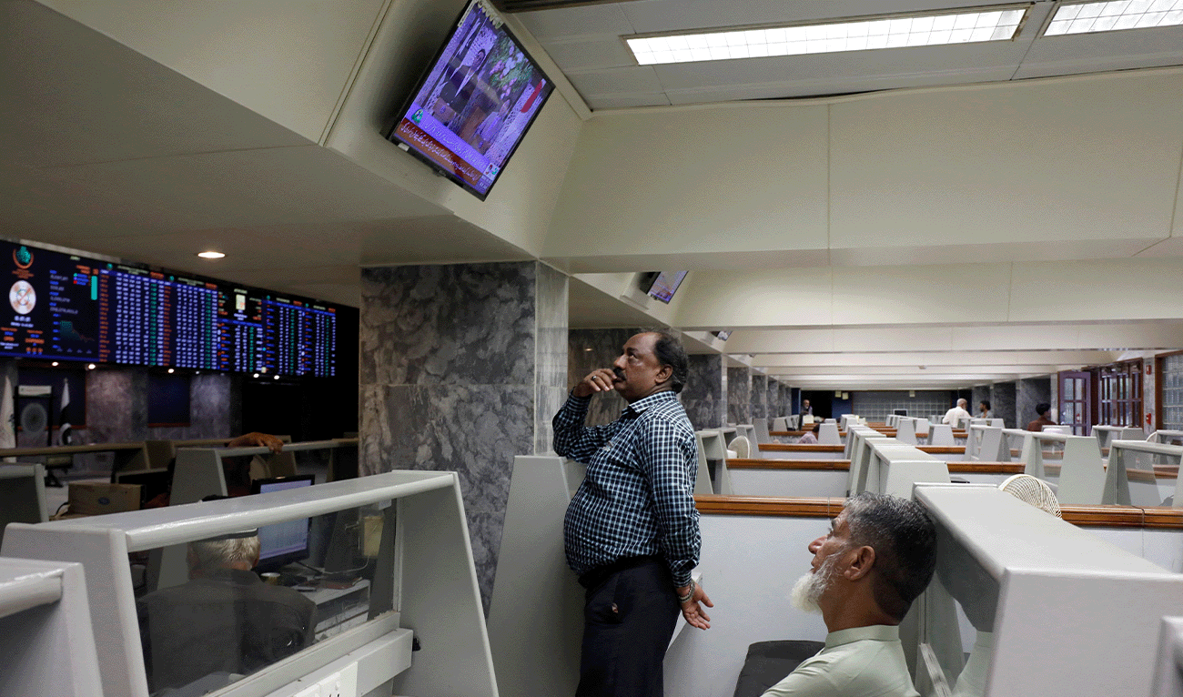 Stock brokers monitor new on television screen at a booth, during a trading session at the Pakistan Stock Exchange, in Karachi, Pakistan July 3, 2023. (Reuters/File)