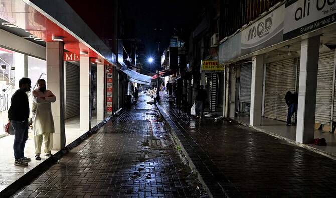 People stand in a market that closed early in the evening in Islamabad on April 7, 2026 following the Pakistani government’s decision to shut down markets and shopping malls to conserve energy as fuel prices surge due to the ongoing Middle East war. (AFP/ file)