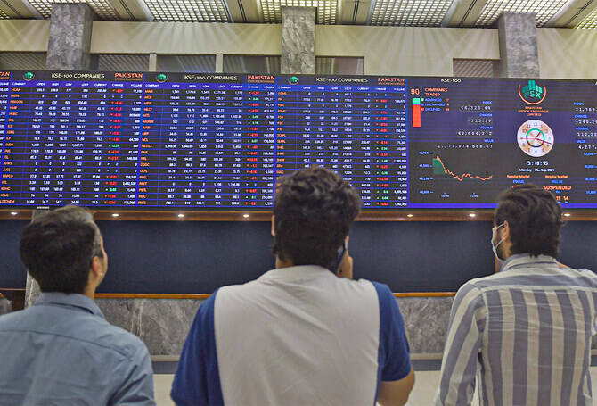Stockbrokers watch an index board showing the latest share prices during a trading session at the Pakistan Stock Exchange (PSX) in Karachi, Pakistan, on September 20, 2021. (AFP/File)