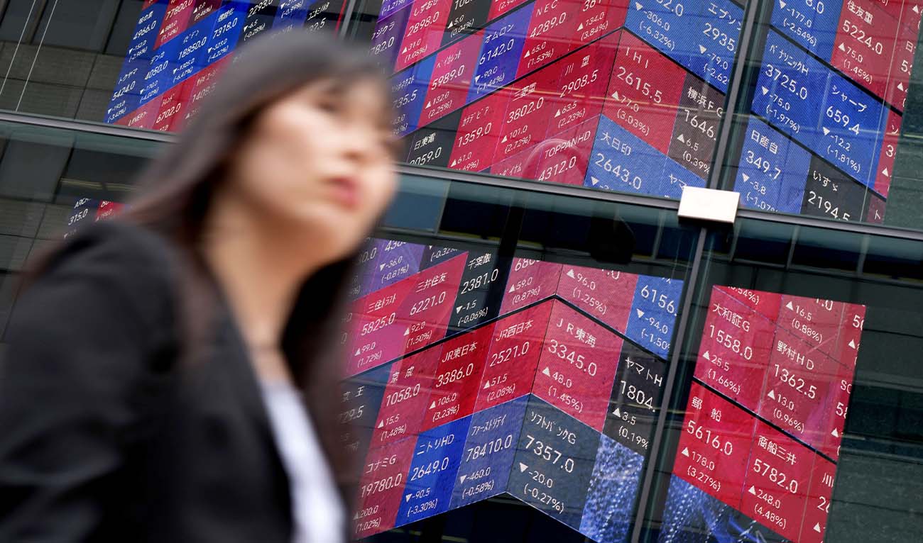 A woman walks past an electronic quotation board displaying the Nikkei 225 stock prices on the Tokyo Stock Exchange along a street in Tokyo on June 5, 2026. (AFP/ file)