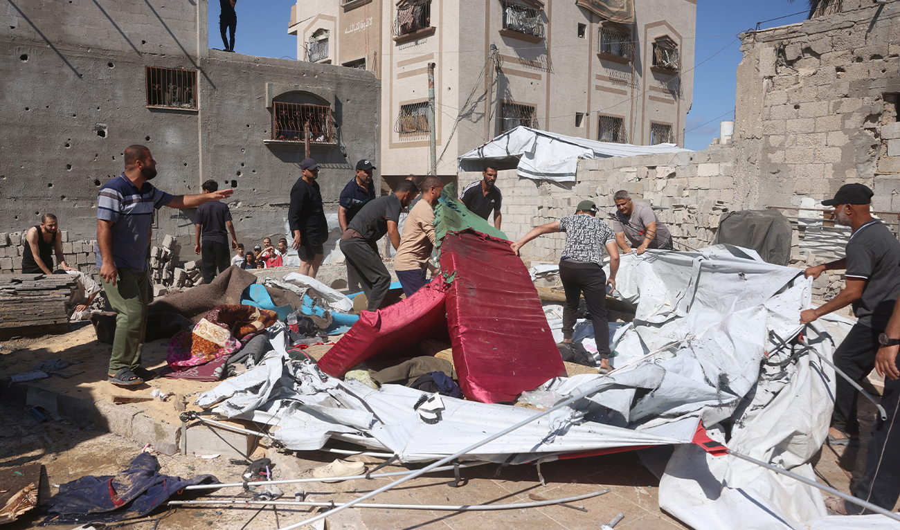 Displaced Palestinians remove the sand and debris following an Israeli military strike on their tent homes, in Khan Yunis, southern Gaza Strip, on June 14, 2026. (AFP)