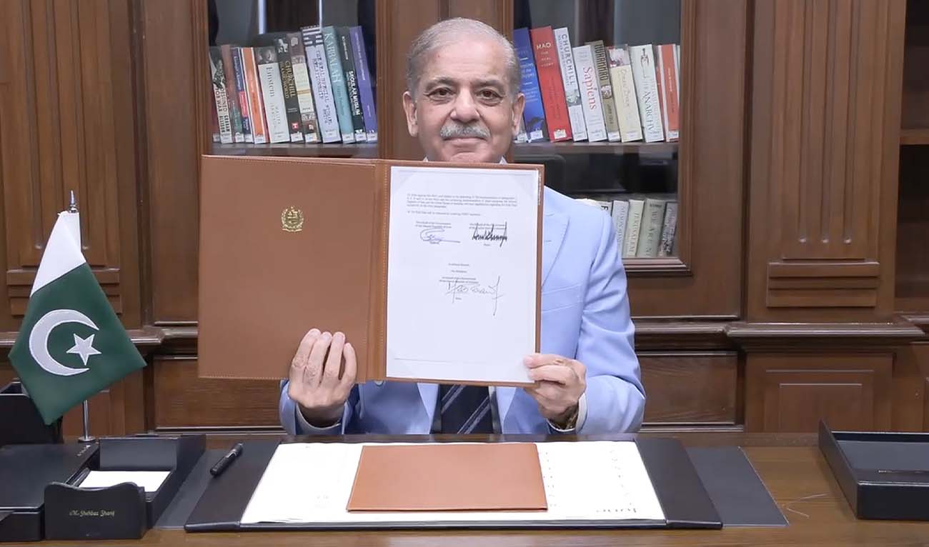 This handout photograph taken and released by Pakistan's Prime Minister's Office on June 18, 2026 shows Pakistan's Prime Minister Shehbaz Sharif holding the memorandum of understanding after signing it as a peace mediator to end the Middle East war, in Islamabad. (AFP/ PMO)