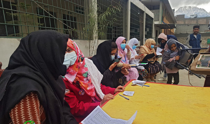Women voting officers check serial numbers for voters at the gate of a polling station in the Gilgit district of Gilgit-Baltistan in Pakistan. (AN photo/Nisar Ali)