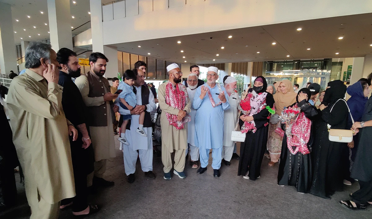 Relatives gather at Islamabad International Airport to receive Imran Qureshi (fifth-left) upon his return after performing Hajj, in Islamabad, Pakistan, on June 11, 2026. (AN Photo)