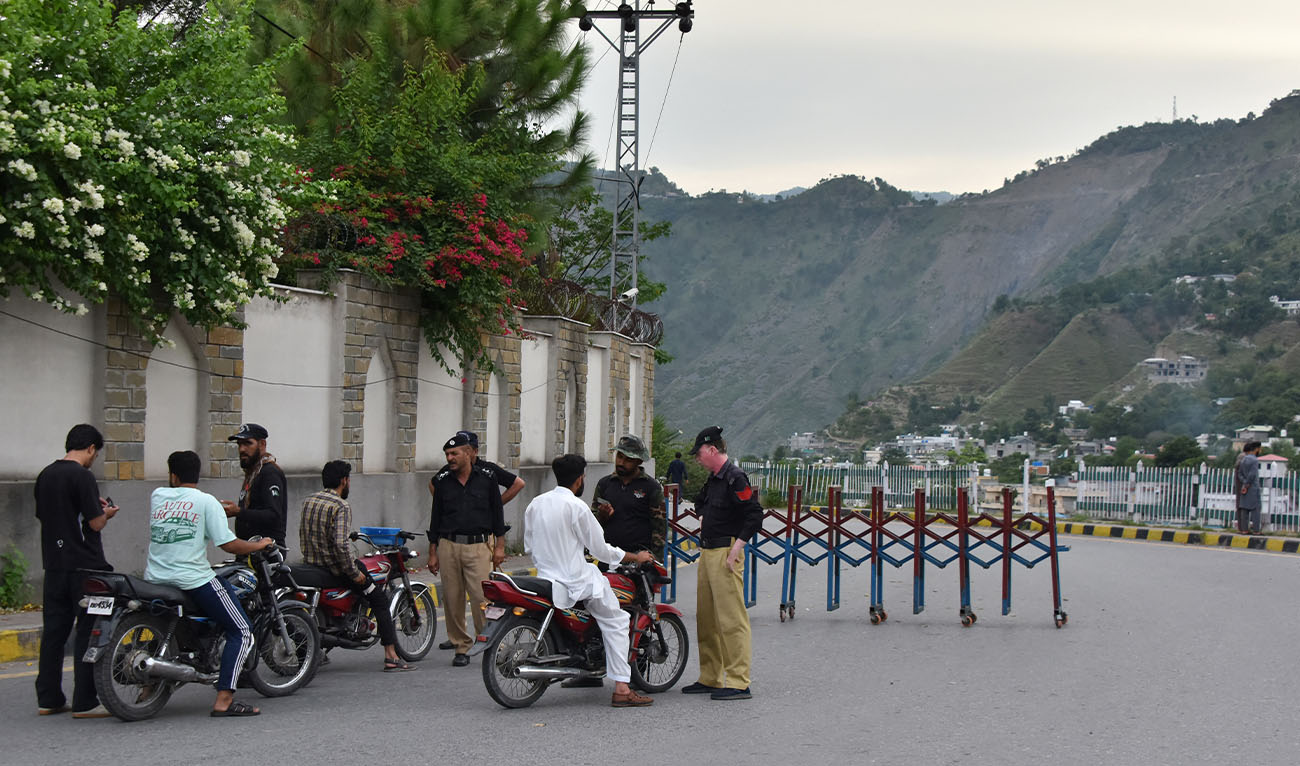Police frisk people at a checkpoint in Muzaffarabad, the capital of Pakistan-administered Kashmir on July 15, 2026. (AFP/File)
