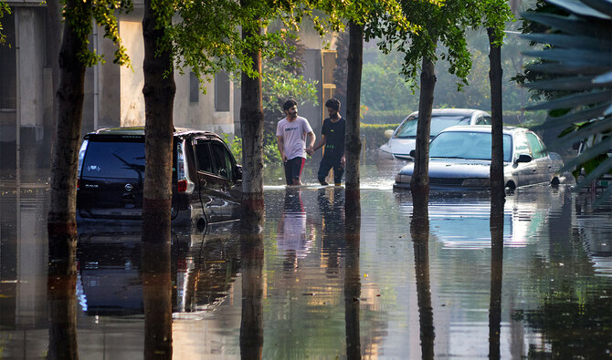 People wade through a flooded street after heavy rainfall in Faisalabad on August 5, 2024. (AFP)