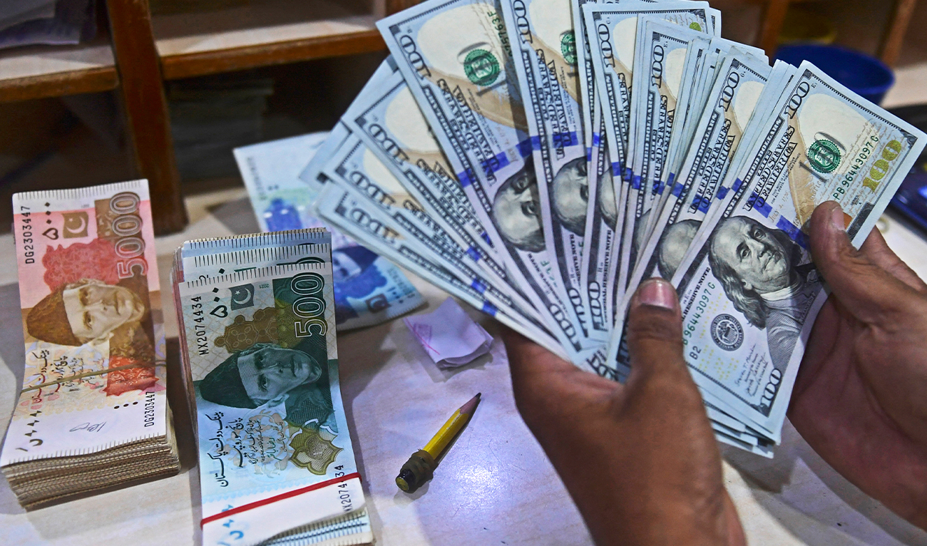 A foreign currency dealer counts US dollars at a shop in Karachi on May 19, 2022. (AFP/ file)