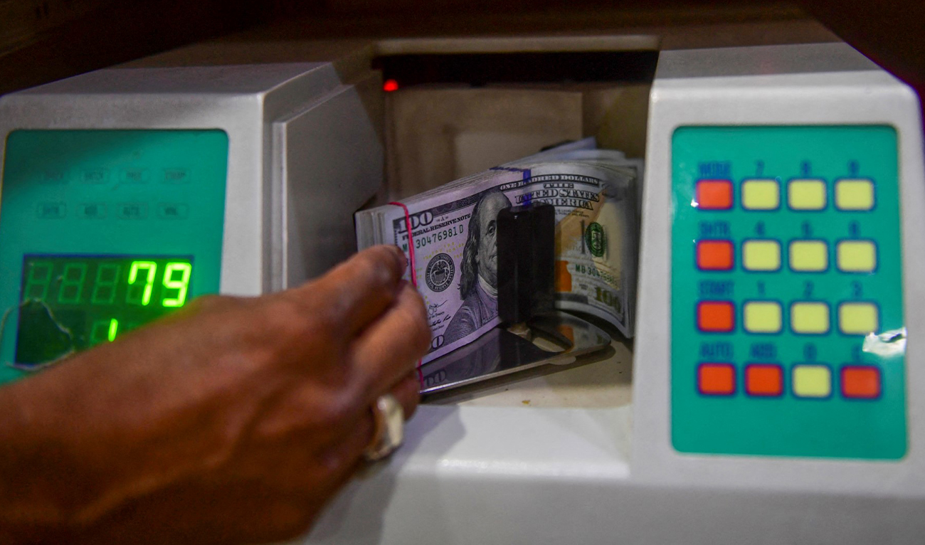 A foreign currency dealer counts US dollars at a shop in Karachi, Pakistan, on May 19, 2022. (AFP/File)