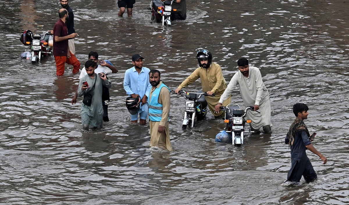 People wade through a flooded street after heavy rainfall in Lahore on July 22, 2026. (AFP/File)