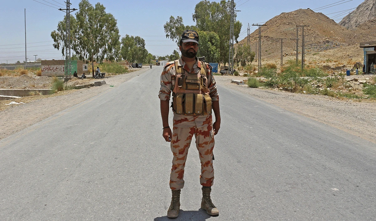 A security personnel stands guard along a street near the site of a school bus bombing in the Khuzdar district of Balochistan province on May 21, 2025. (AFP/File)