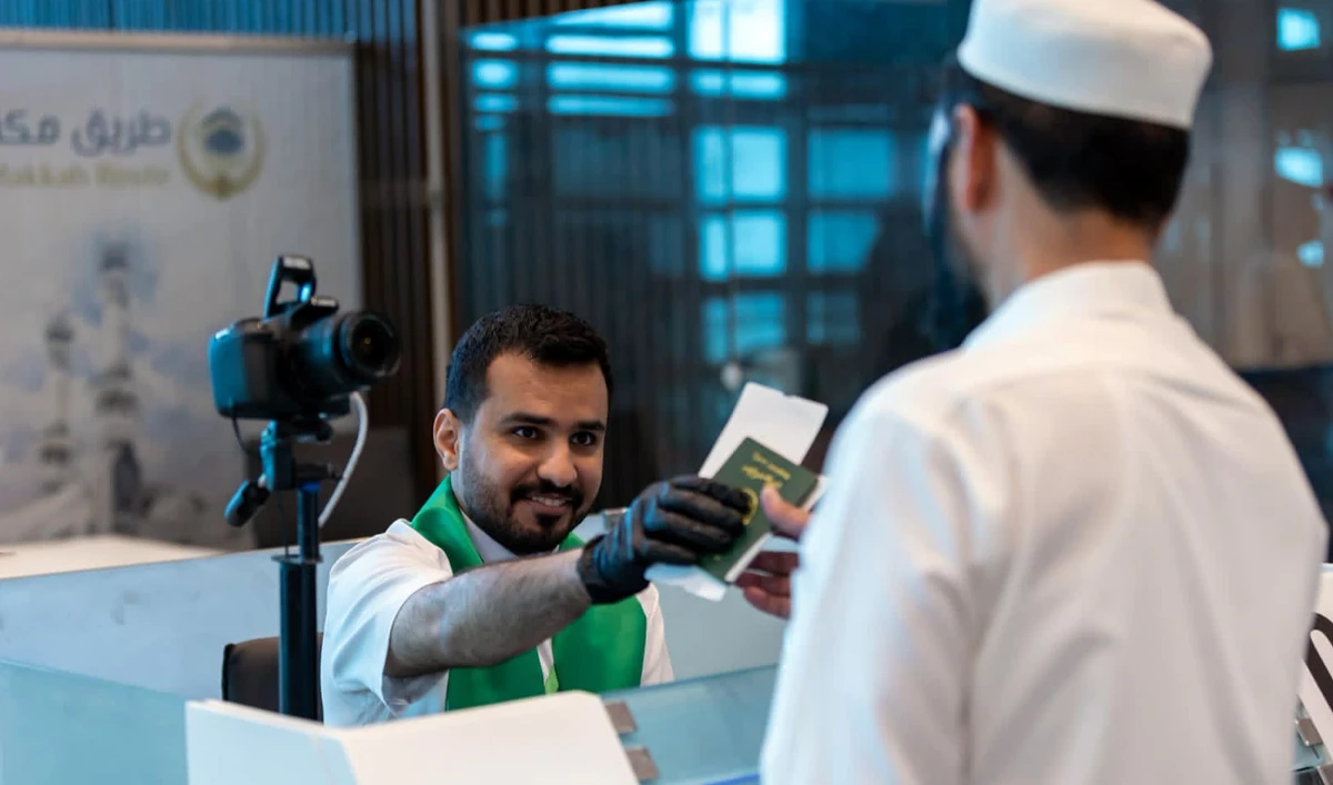 The handout photograph released on May 22, 2026, shows a Hajj pilgrim receiving his passport from an official at the Islamabad International Airport in Islamabad, Pakistan. (PAA/File)