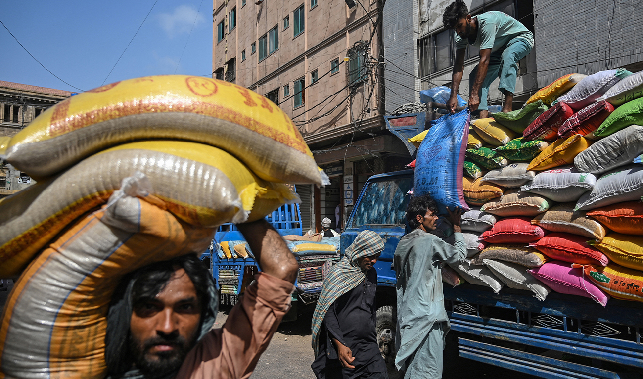 Labourers load sacks of rice onto a truck at a market in Karachi, Pakistan, on June 10, 2024. (AFP/File)
