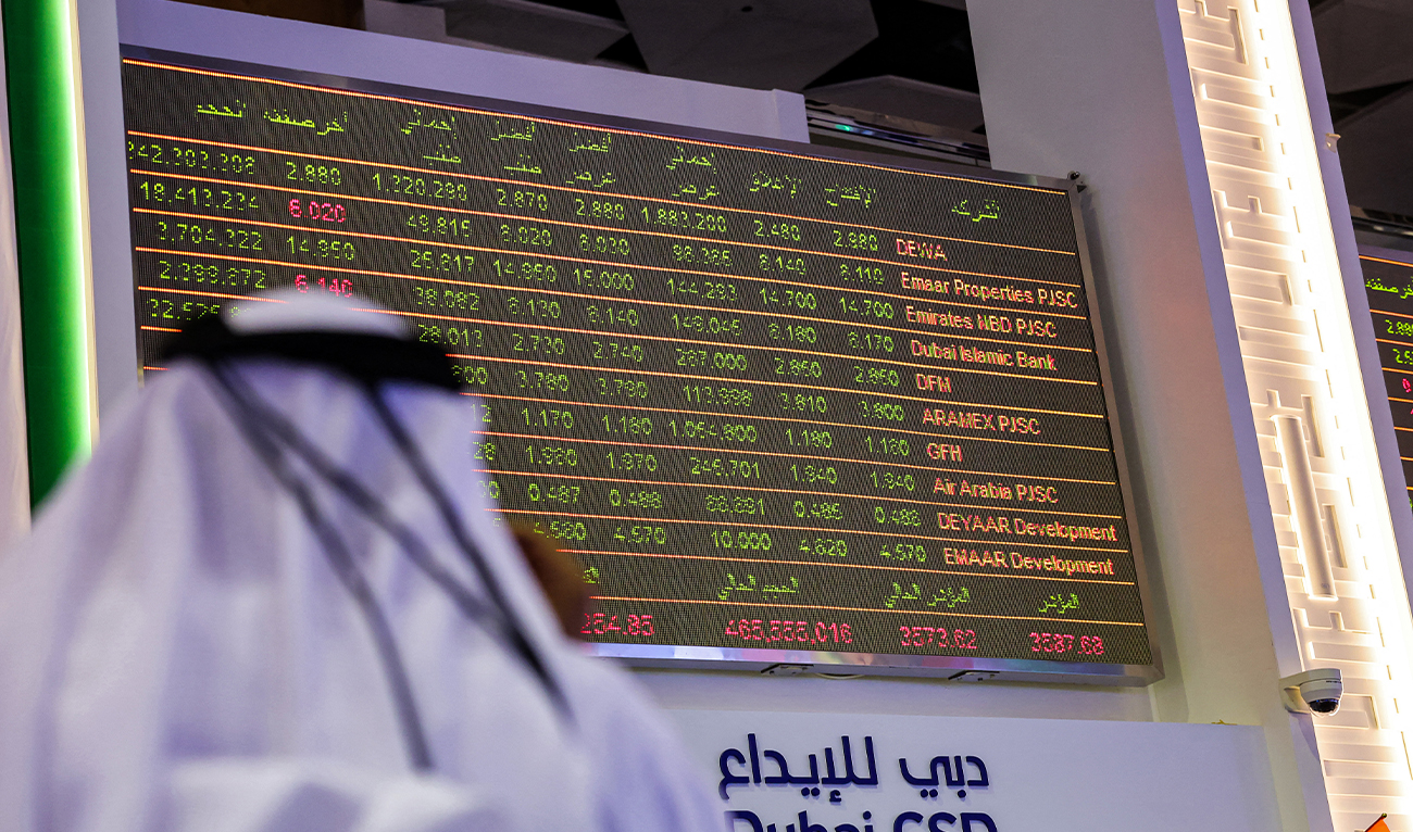 A man watches stock movements on a display at the Dubai Financial Market stock exchange in the Gulf emirate on April 12, 2022. (AFP/ file)