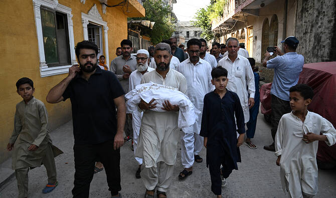 A man carries the body of a newborn child who died following a fire at the Mother and Child Health (MCH) ward of the Pakistan Institute of Medical Sciences (PIMS) Hospital, during a funeral in Rawalpindi on August 26, 2026. (AFP/File)