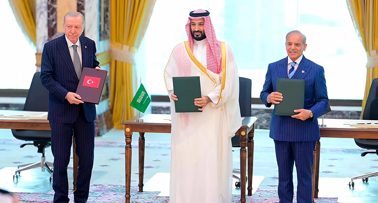 This handout photograph taken and released by Pakistan's Prime Minister's Office on August 7, 2026 shows Saudi Crown Prince Mohammed bin Salman (center), Turkish President Recep Tayyip Erdogan (left) and Pakistani Prime Minister Shehbaz Sharif posing after signing the Mecca Joint Defence Agreement in Mecca, Saudi Arabia. (AFP/File)