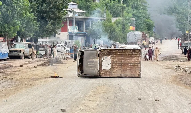 People walk along a street after protestors blocked a road with the wreckage of a vehicle following clashes with police in Muzaffarabad on July 31, 2026. (AFP/ file)