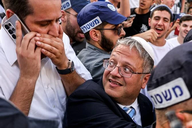 イスラエルの国家安全保障相で極右政治家のイタマル・ベングビール氏が、エルサレムの旧市街の城壁にあるダマスカス門の外に集まった右派活動家たちを見守る。(AFP)