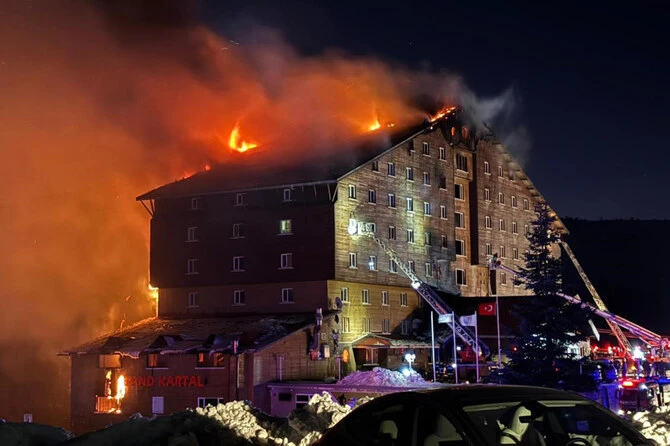 Firefighters work to extinguish a fire in a hotel at a ski resort of Kartalkaya in Bolu province, in northwest Turkiye on Jan. 21, 2025. (IHA via AP)