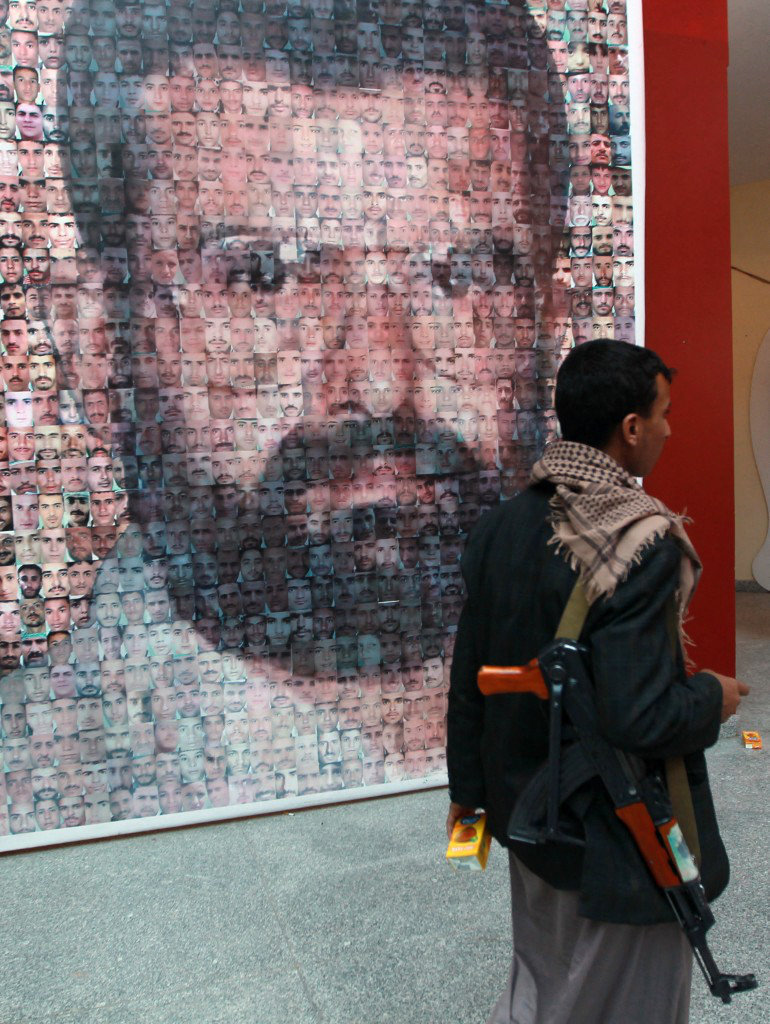Un milicien houthi passe devant un portrait de Hussein Badr Eddin al-Houthi, ancien chef du mouvement houthi et frère aîné de l’actuel chef Abdel Malek al-Houthi, à Saada, au Yémen. (Archives AFP)