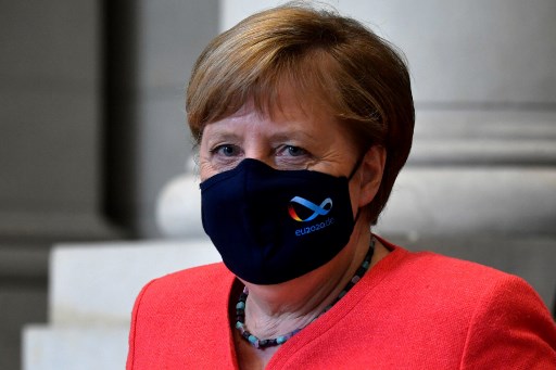 La chancelière Angela Merkel quittant le Bundesrat le 3 juillet, protégée par un masque marqué du logo de la présidence allemande de l’Union européenne.