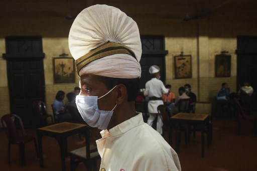 Un serveur portant un masque dans un café de Calcutta (Dibyangshu SARKAR/AFP)