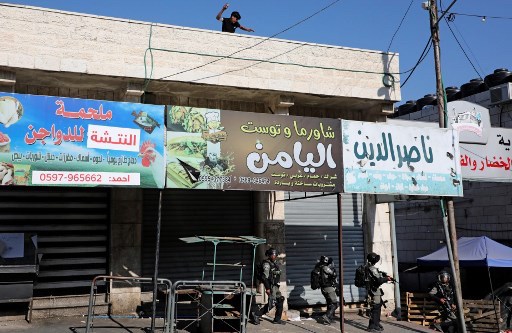 A Hébron, un Palestinien se prépare à jeter une pierre sur des garde-frontières lors de manifestations contre le plan d’annexion israélien de parties de la Cisjordanie. Hazem BADER/AFP