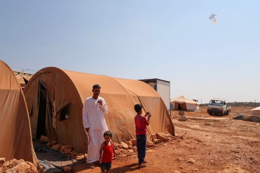 Un enfant fait voler un cerf-volant dans un camp de déplacés des provinces Idleb et d’Alep. (Omar HAJ KADOUR/AFP)