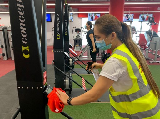 Dans une salle de gym à Riyad, une femme portant un masque désinfecte une machine avant une session d’entrainement. Rania SANJAR/AFP