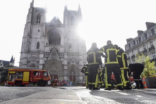 Pompiers à l’œuvre devant la cathédrale Saints Pierre et Paul de Nantes touchée par un incendie « majeur » le 18 juillet. (Sebastien SALOM-GOMIS/AFP)