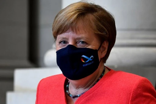La chancelière Angela Merkel quittant le Bundesrat le 3 juillet, protégée par un masque marqué du logo de la présidence allemande de l’Union européenne.